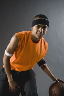 Mixed race basketball player dribbling basketball