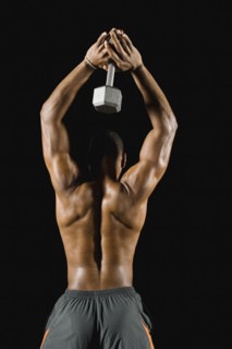 African man doing triceps extensions with dumbbell