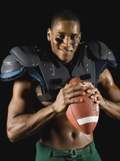 African football player holding football and wearing protective pads