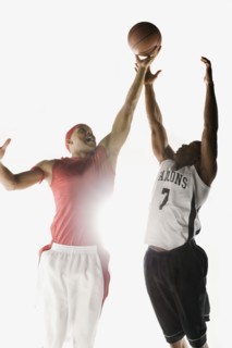 African men jumping for basketball