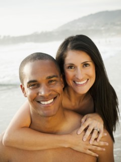 Smiling couple hugging on beach