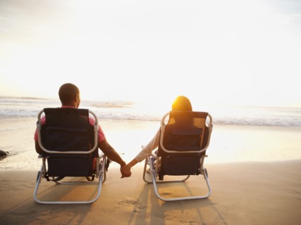 Couple holding hands on beach at sunset