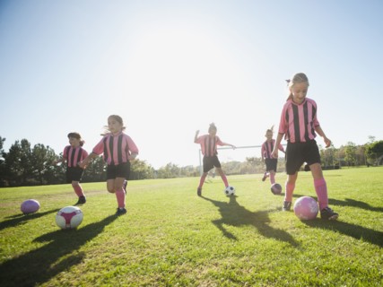 Girl soccer players practicing with soccer balls