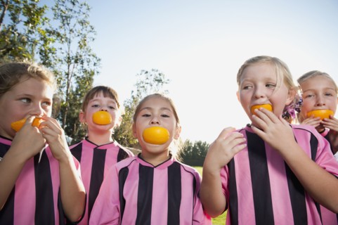Girl soccer players eating orange slices