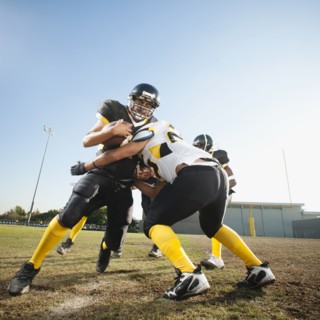 Football player tackling player on football field