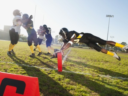 Football player scoring goal on football field