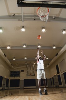 Black man shooting basketball on basketball court