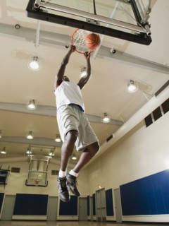 Black man shooting baskets on basketball court