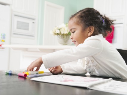 Mixed race girl drawing in notebook