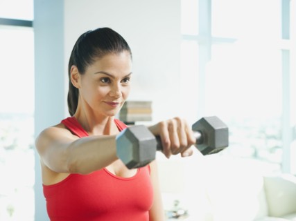 Mixed race woman exercising with dumbbells