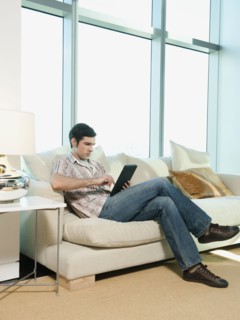 Caucasian man using digital tablet in living room