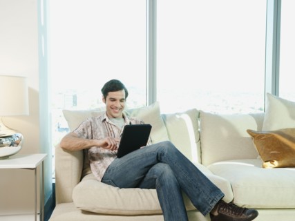 Caucasian man using digital tablet in living room