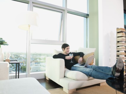 Man drinking wine and using laptop