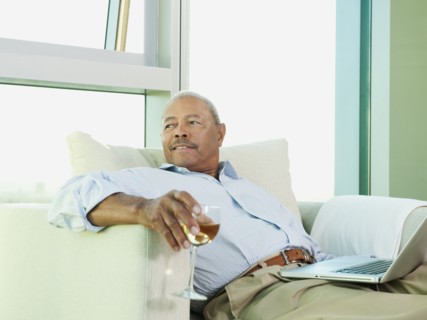 Black man drinking wine and reading book