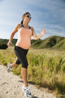 Pregnant Hispanic woman running in remote area