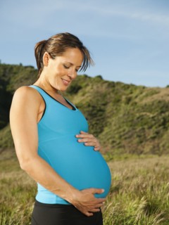 Pregnant Hispanic woman caressing her stomach