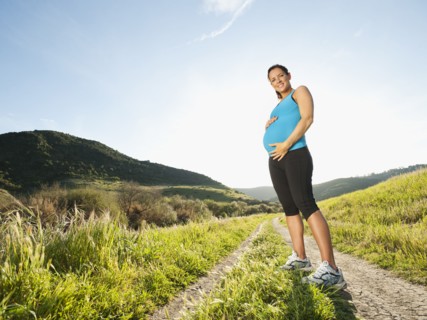 Pregnant Hispanic woman standing in remote area