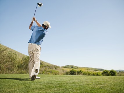 Caucasian golfer swinging golf club