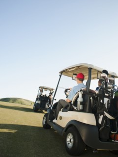 Men driving golf carts on golf course
