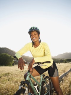 Mixed race biker standing with mountain bike