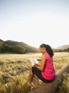 Black woman reading book in remote area