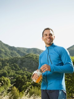 Athletic mixed race man drinking water outdoors