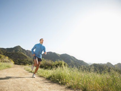 Mixed race man running on remote trail