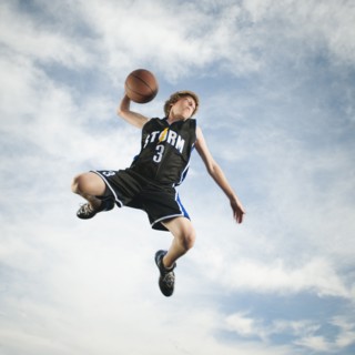 Caucasian teenager playing basketball