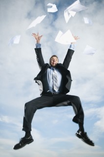 Caucasian businessman jumping in air scattering papers