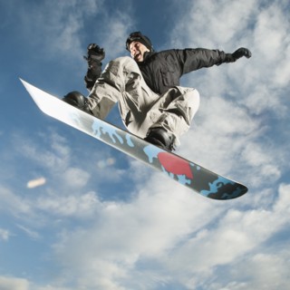 Caucasian man on snowboard in mid-air
