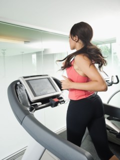 Mixed race woman running on treadmill