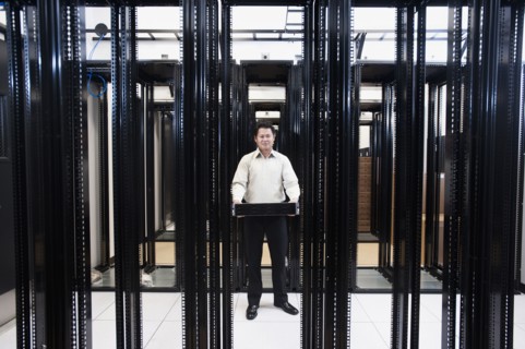 Asian businessman standing in empty server room