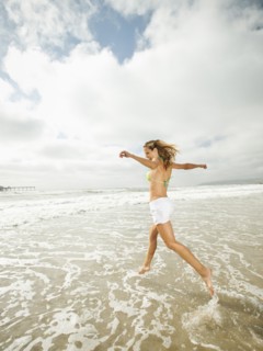 Caucasian woman running in ocean