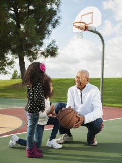 Man playing basketball with granddaughters