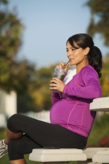 Pregnant Hispanic woman having health drink