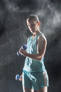 Hispanic woman lifting weights in rain