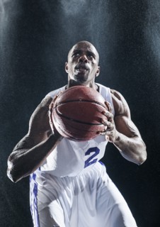 African American basketball player standing in rain