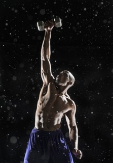African American athlete lifting weights in rain