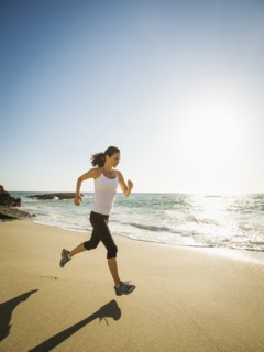 Mixed race woman running on beach