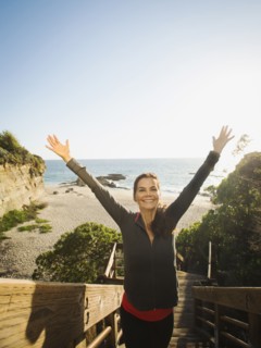 Mixed race woman climbing steps on beach