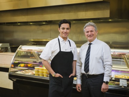 Hispanic businessman and worker in kitchen