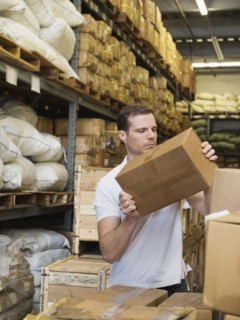 Caucasian worker stacking boxes in textile factory