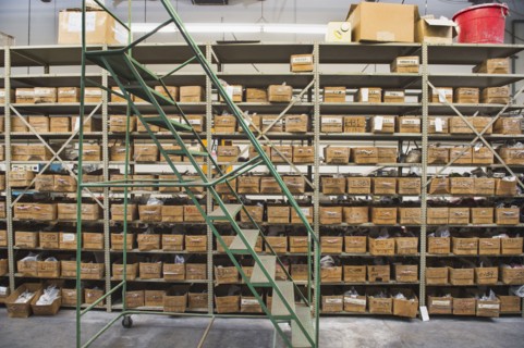 Rolling stairs by shelves in textile factory