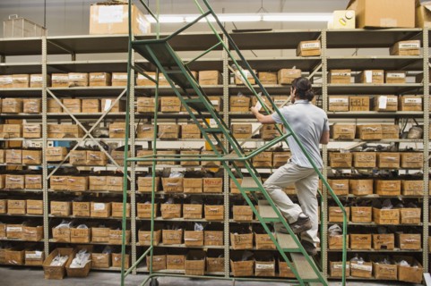 Mixed race worker examining boxes in textile factory