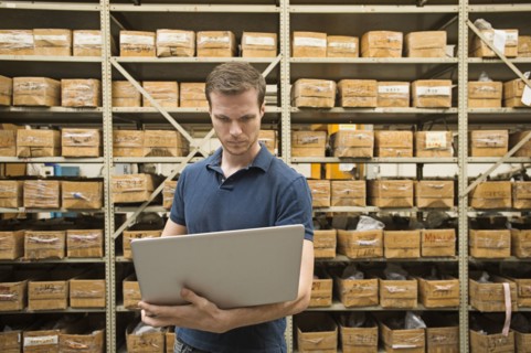 Caucasian worker using laptop in textile factory