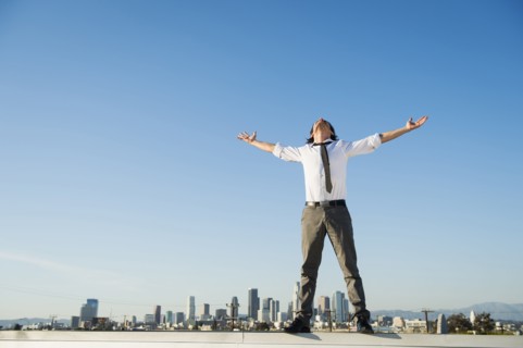 Mixed race businessman standing on urban rooftop