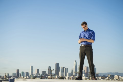 Caucasian businessman standing on urban rooftop