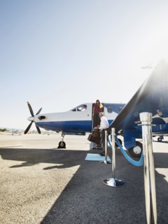 Business people disembarking airplane on runway