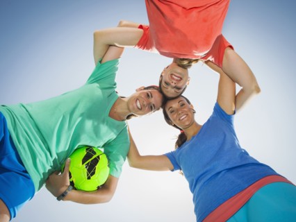 Caucasian women smiling in huddle under blue sky