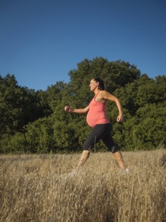 Pregnant Hispanic woman walking outdoors